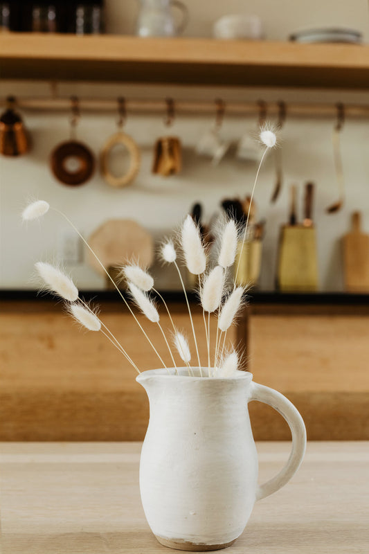 old-white-dandelions-in-a-white-jug-on-a-wooden-table